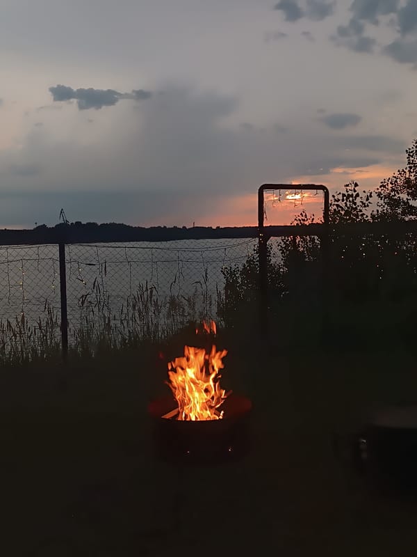 Lakeside campfire evening with a wooden swing in Chaikovsky