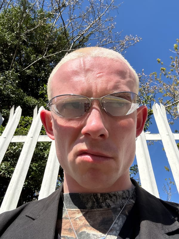 Man in sunglasses photographed near fence, filmed on London transport