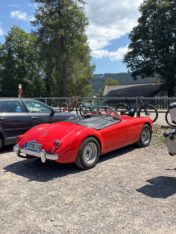 Red vintage convertible parked on gravel in Titisee-Neustadt