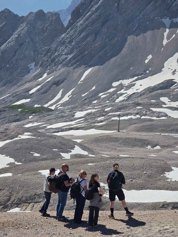 Hikers and snow groomers on a clear morning in the Bavarian Alps
