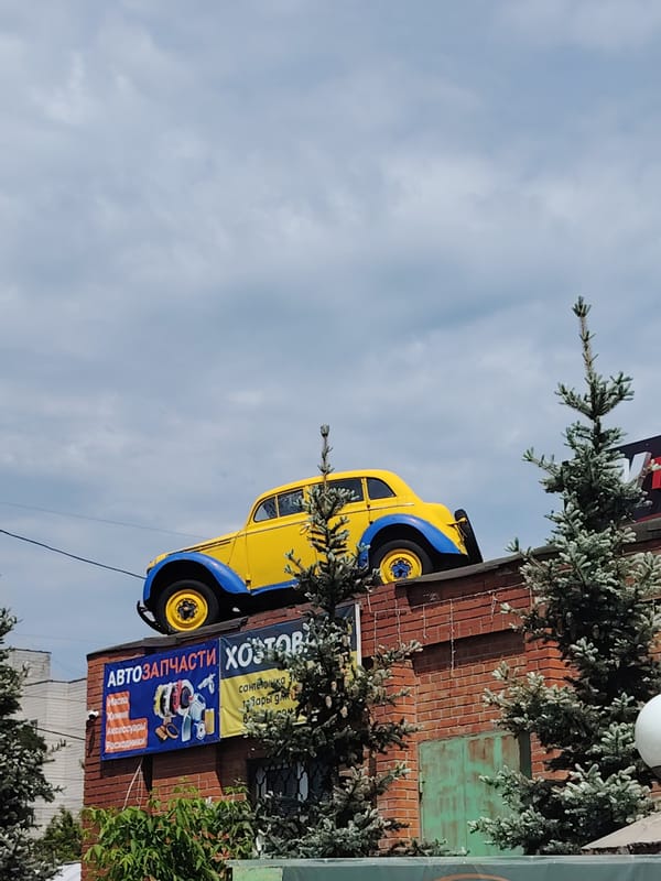 Vintage car serves as rooftop advertisement for autoparts shop