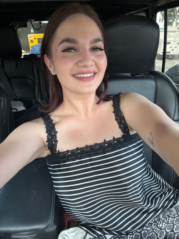 Woman takes smiling selfie in car in Sofia
