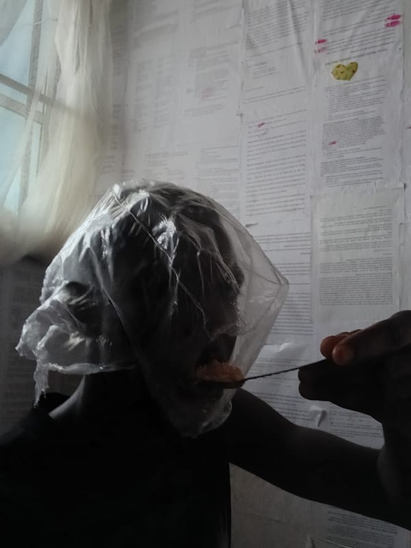 Person eating meal on floor in Akwete, Nigeria