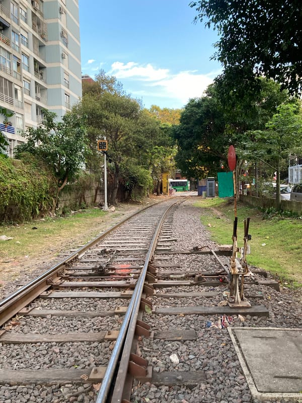 Person walks railway tracks in Buenos Aires evening