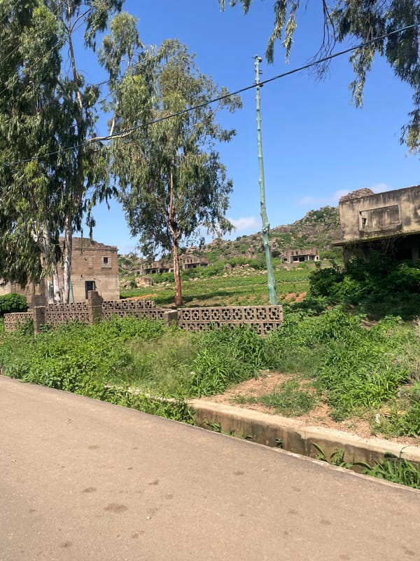 Gura Top street scene: paved road, red soil planter, open sky
