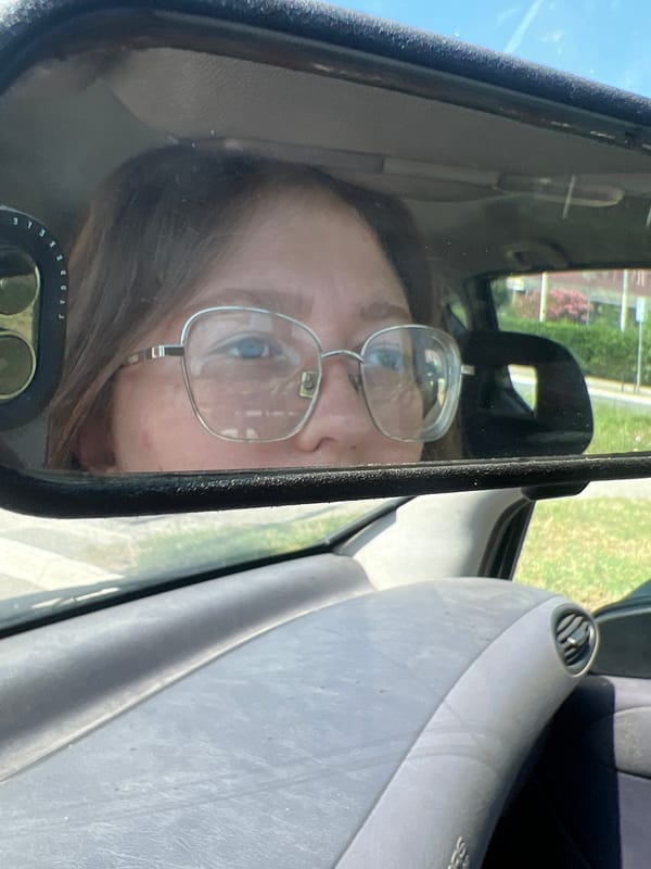 Person with glasses spotted in car rearview mirror in Podgorica