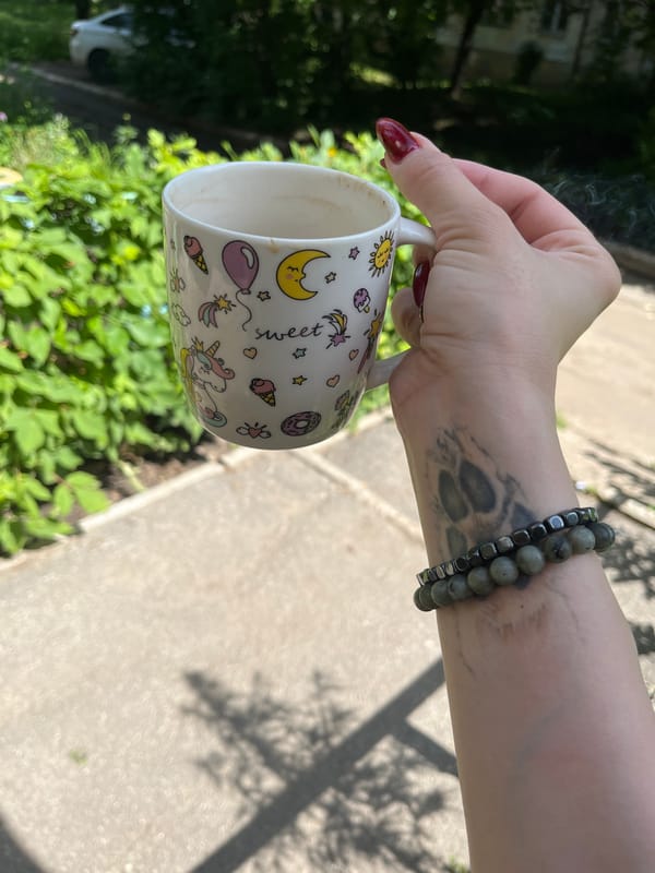 Morning coffee, a small dog, and a sunny urban street