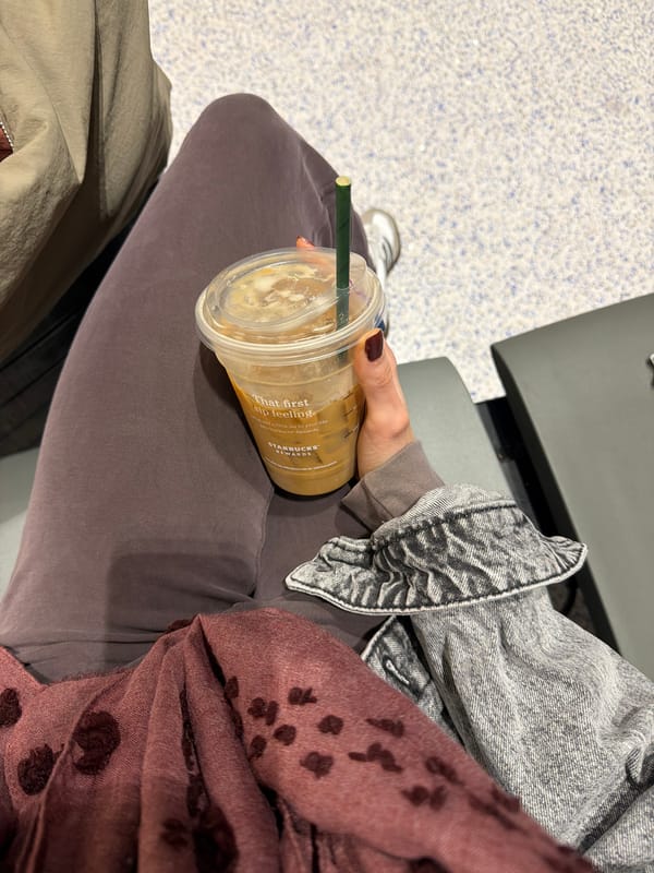 Traveler waits at Newark airport with Starbucks coffee