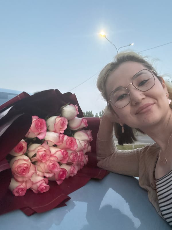 Woman receives rose bouquet in Astana, poses with car