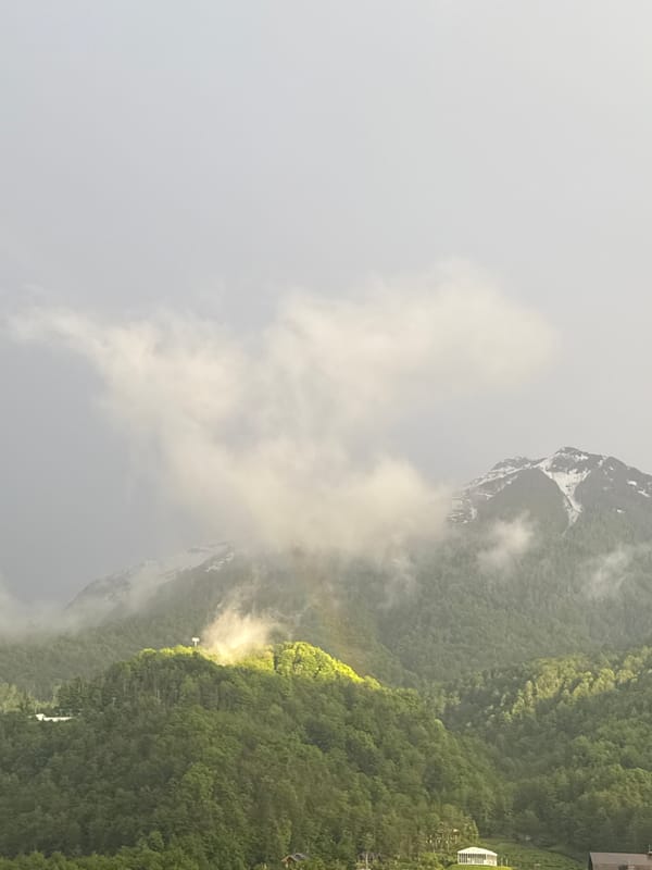 Rainbow appears through misty mountain weather in Krasnaya Polyana