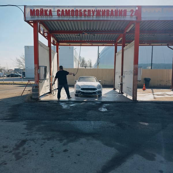 Man washes white Fiat at Saint Petersburg car wash