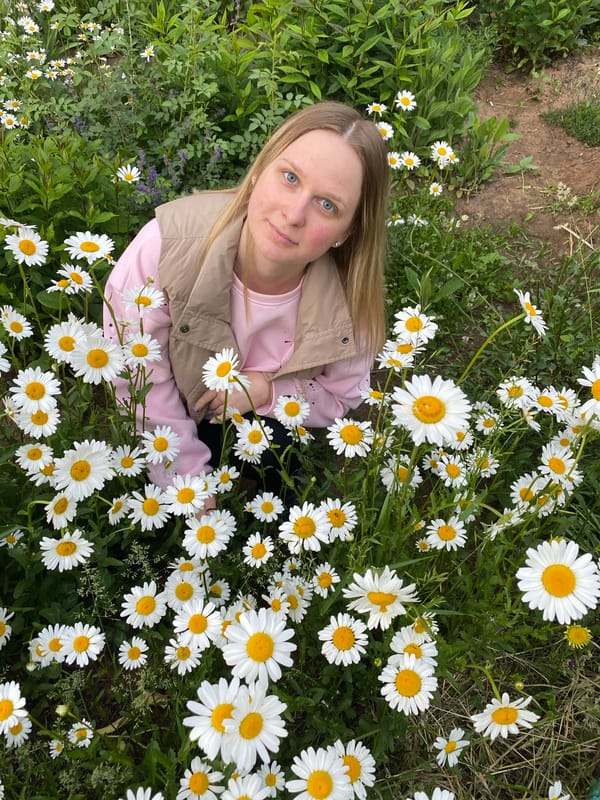 Woman photographed among white daisies in unknown location