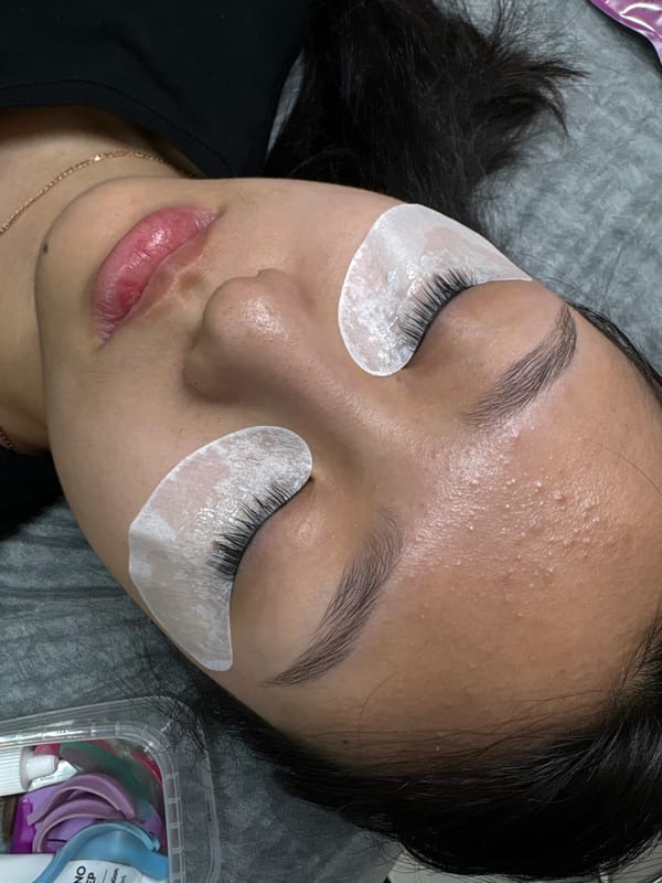 Woman receives eyelash extensions at Perm beauty salon