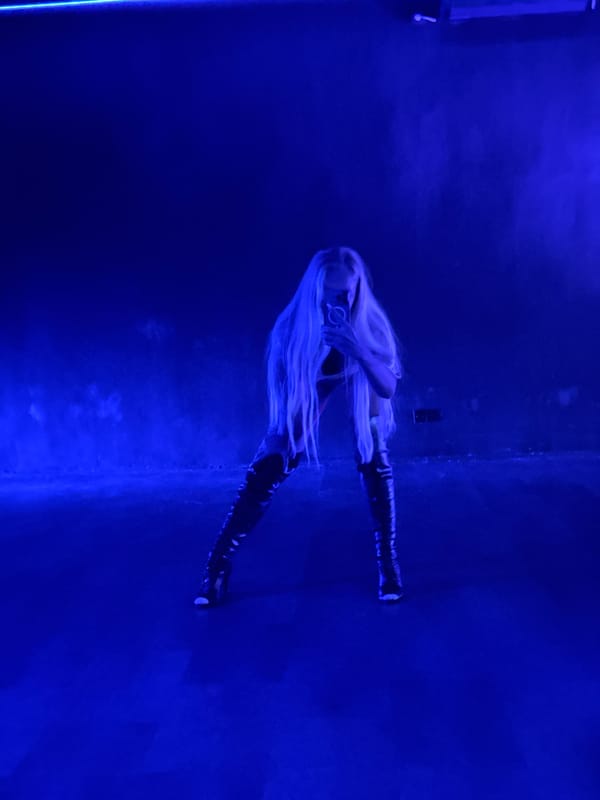 Blonde woman observed in blue-lit room, North Kuta