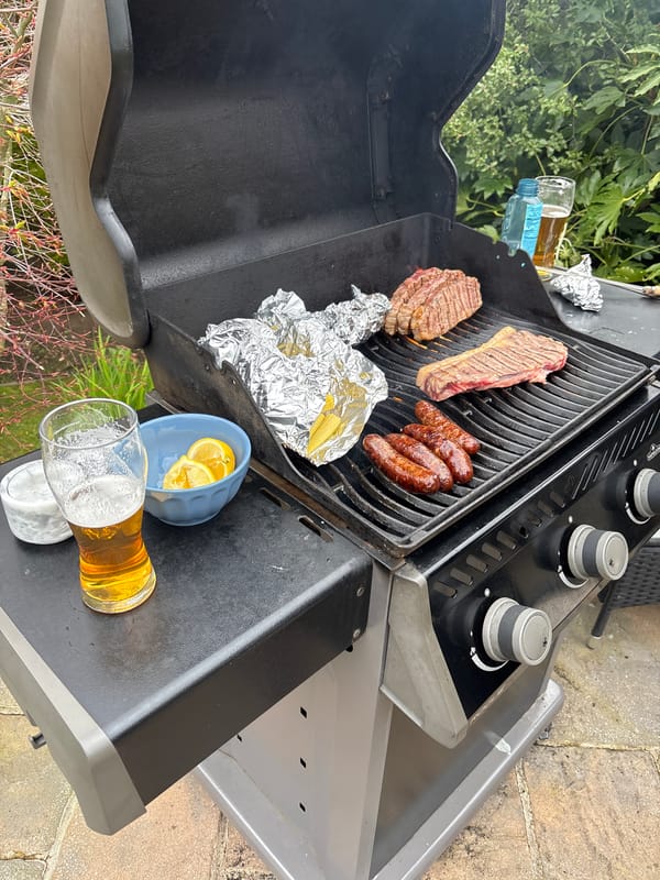 Backyard barbecue cooking steaks and sausages in Welwyn Hatfield
