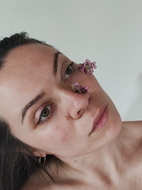 Woman poses with flowers and plant leaves in botanical photo session
