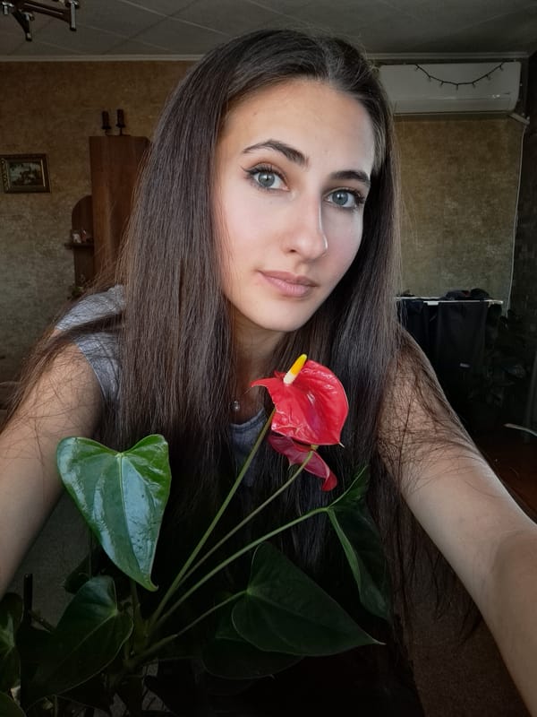 Woman poses with red flowers in Bulgarian home