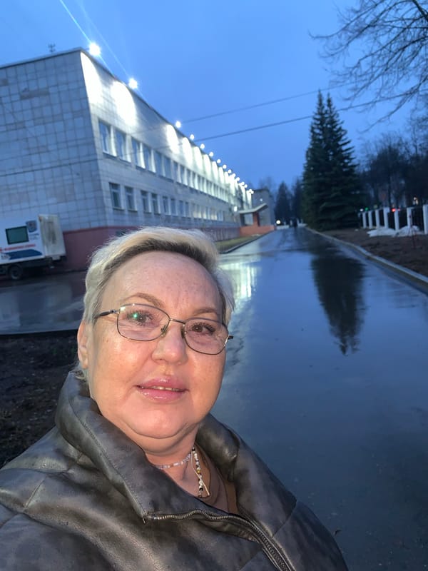 Woman takes late-night selfie on wet pavement in Chaikovsky