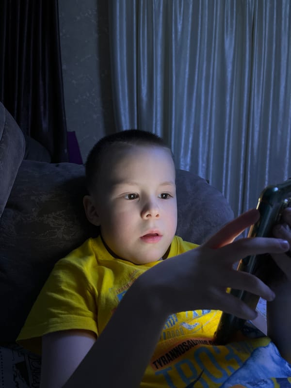Child uses mobile phone on sofa in Usman, Russia