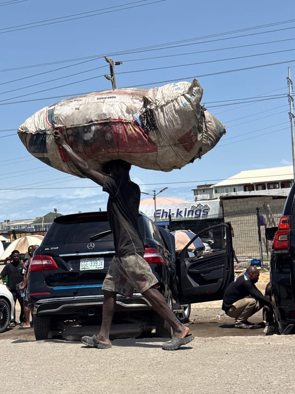 Man carries goods near shipping container in Igboefon, Nigeria