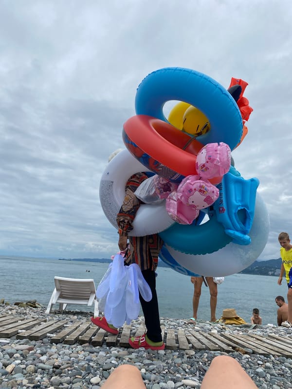 Cloudy morning on Batumi's pebble beach, inflatables in tow