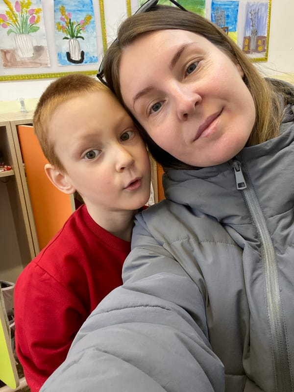 Woman and child share moment near school art display