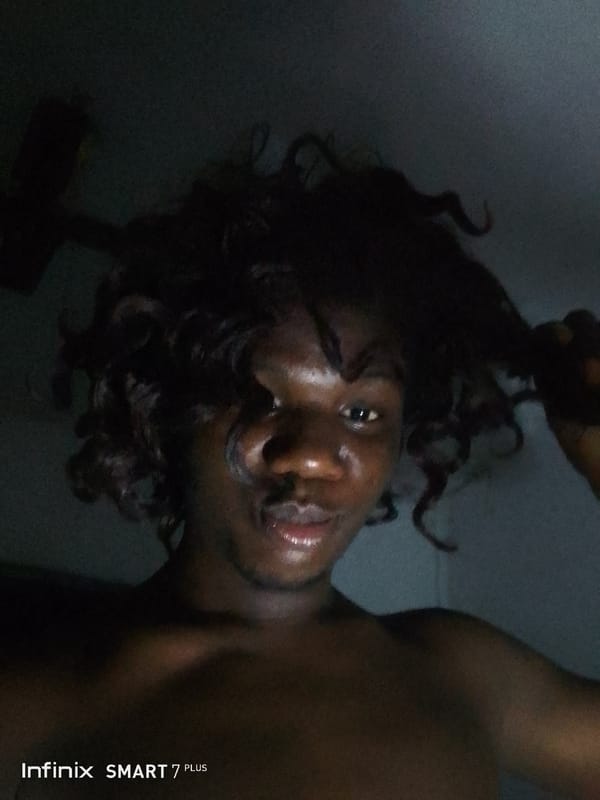 Young adult photographed in low-light selfie session with face paint