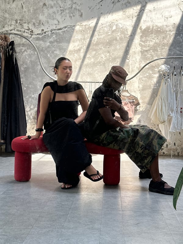 Two people take mirror selfie on red bench in Thủ Đức retail store