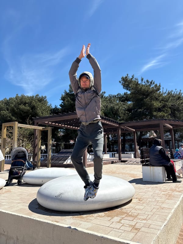 People perform jumping poses at Gelendzhik beach promenade