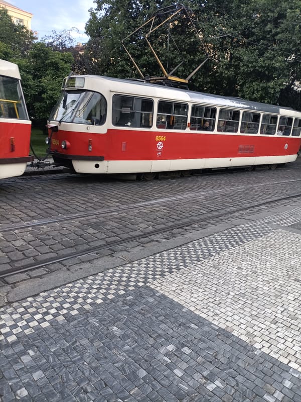 Tourist documents evening tram ride past Prague's St. Ludmila Church