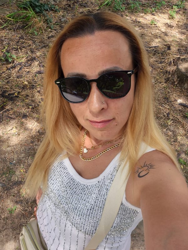 Overhead outdoor selfie, sunglasses and silver sequin top.