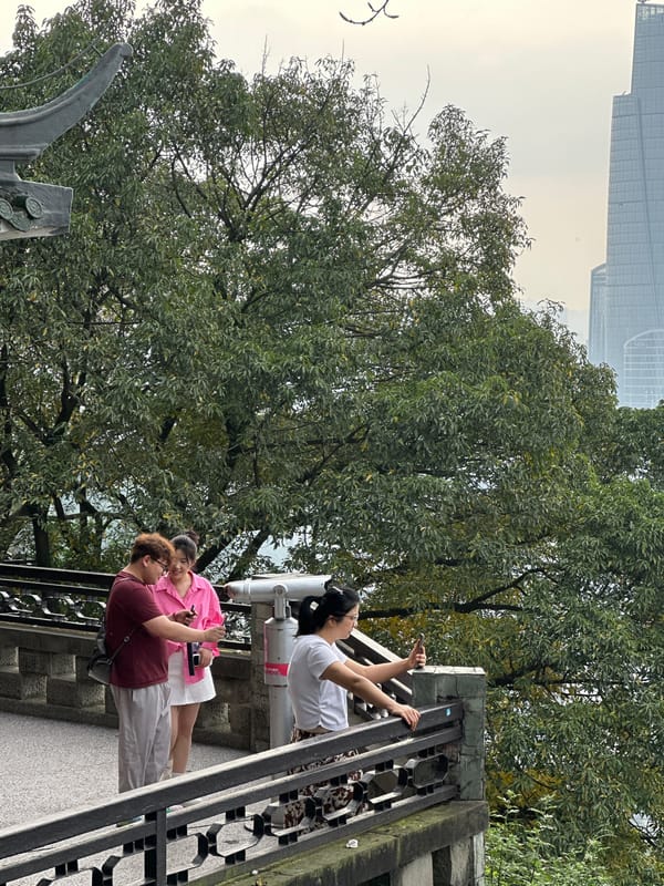 Morning sightseers photograph Chongqing cityscape from pedestrian bridges