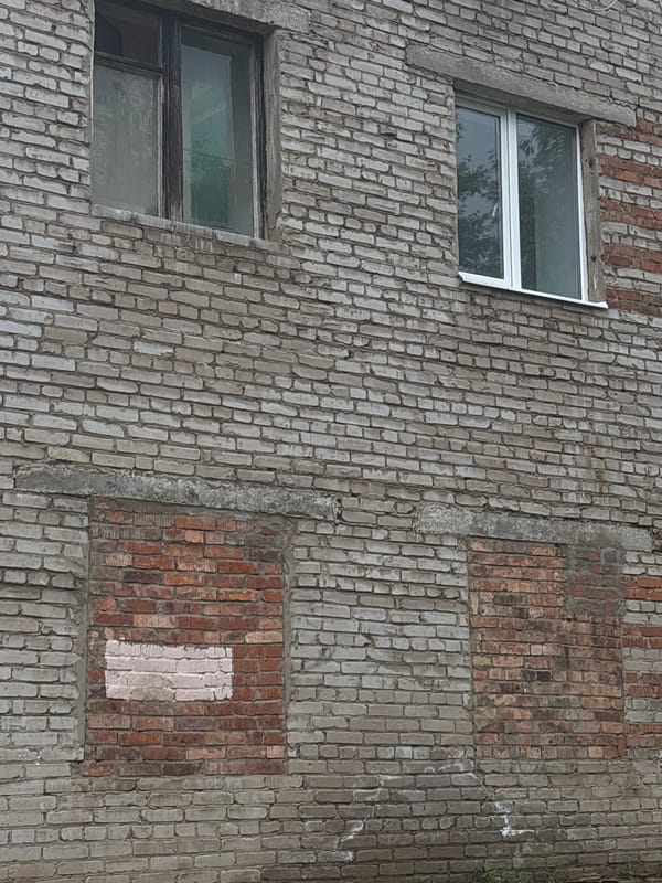 Mixed brick building facade with modern windows documented