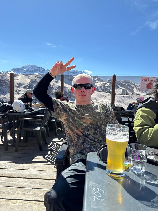 Man makes peace sign at outdoor table in Champéry