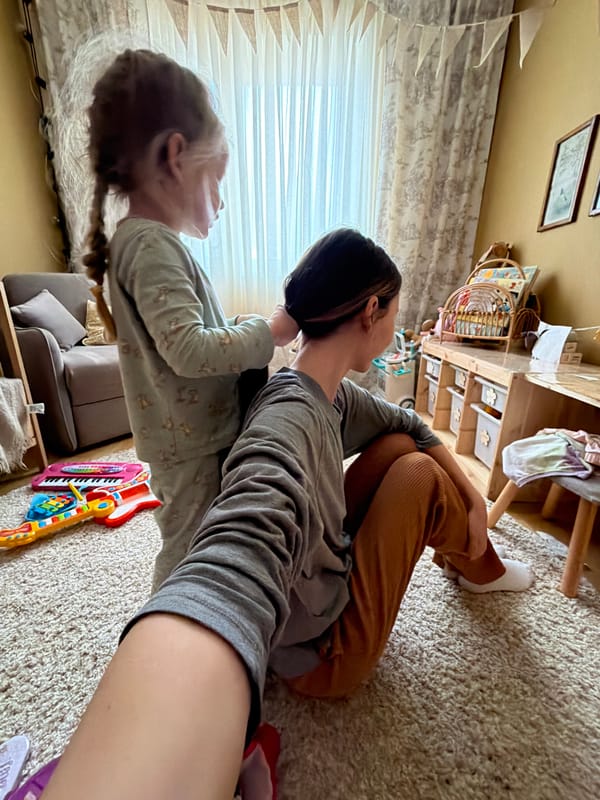 Girl plays with colorful parrot in Russian home