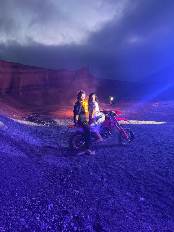 Two people pose with red dirt bike in Teguise