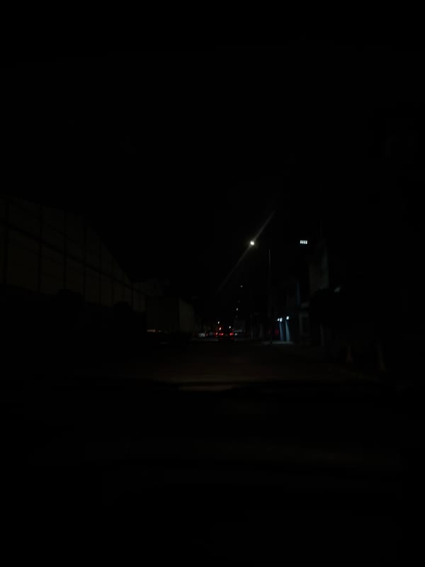 Night documentation of quiet urban alleyway with paved walkway