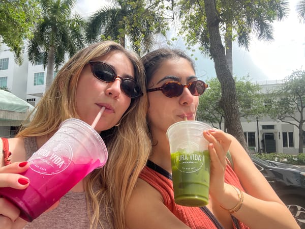 Two women enjoy drinks from Miami Beach cafe