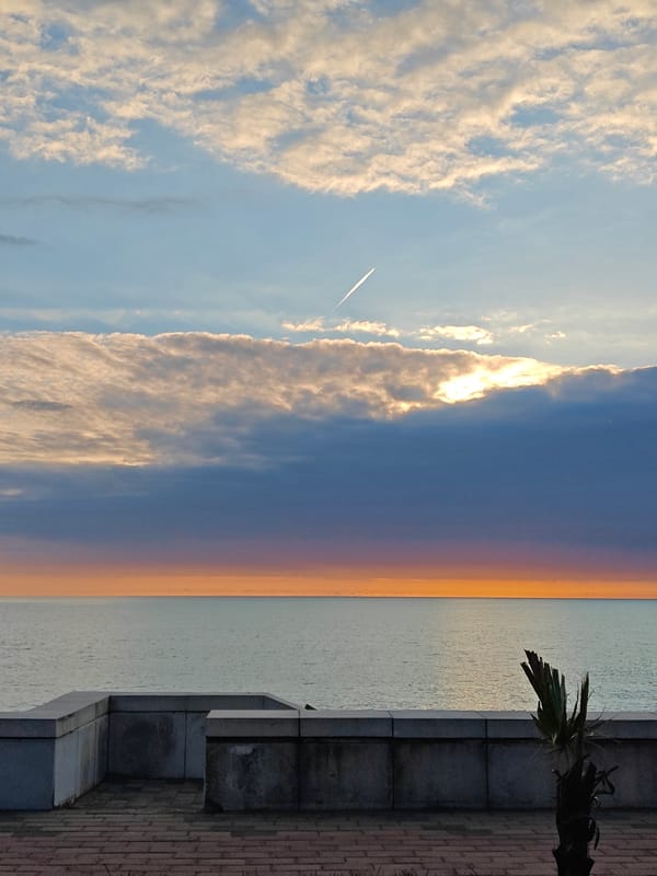 Coastal sunrise/sunset scene captured with brick walkway, dramatic clouds