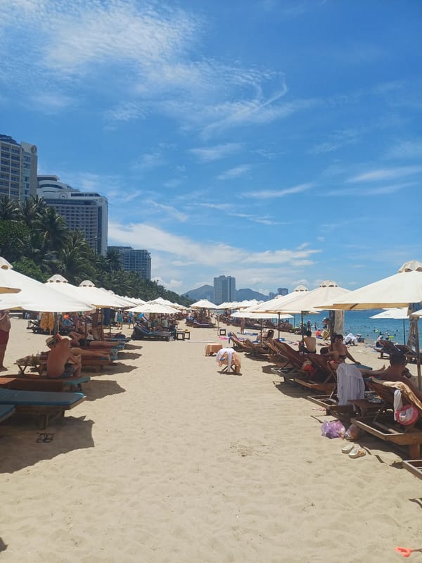 Nha Trang beach life: sand, signage, and a shoreline piano
