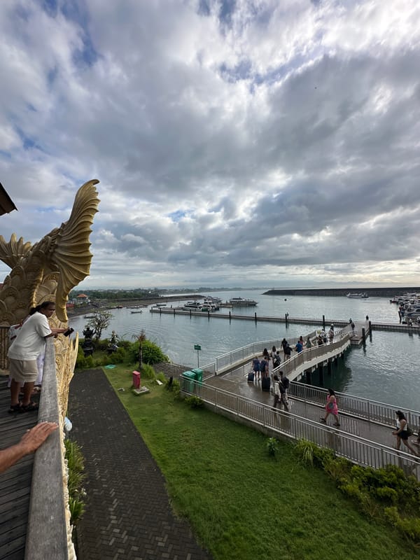 Nighttime marina activity observed near golden dragon statues, Denpasar