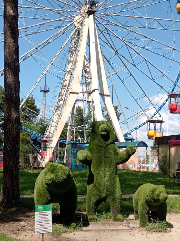 Summer afternoon at a Belogorsk park with rides and sculptures
