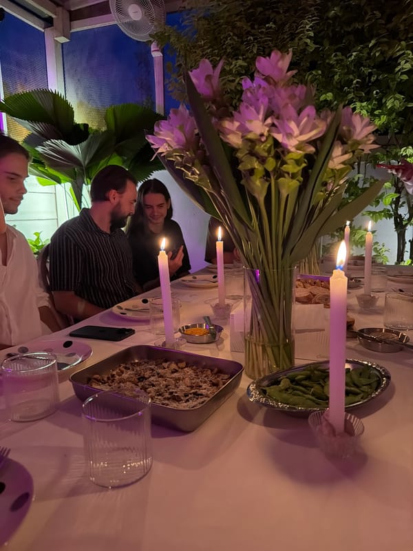 Russian-language birthday dinner party, candlelit outdoor table, Chang Phueak