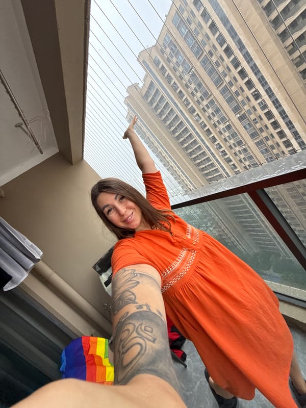 Balcony selfies on a rainy Huizhou morning, rainbow flag in view
