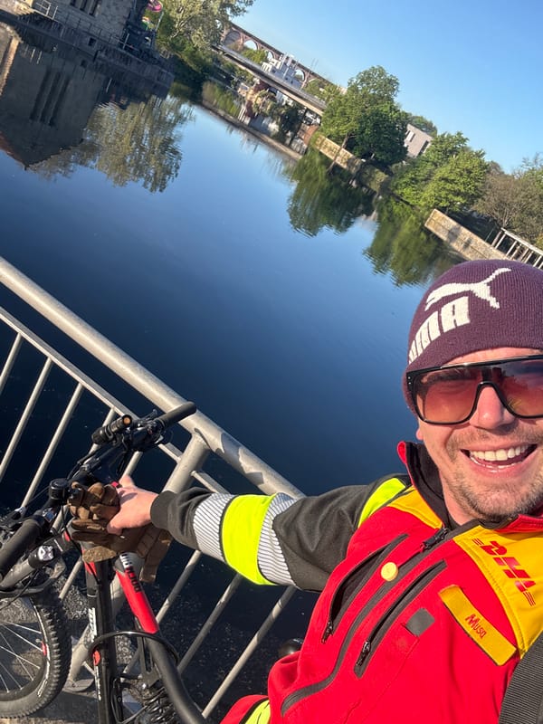 DHL worker poses with bike on German bridge