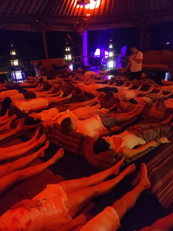 Group gathering on mats in covered space, Blahbatuh Indonesia