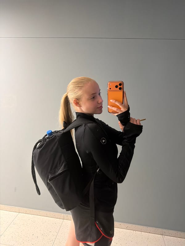 Person takes mirror selfie in athletic wear