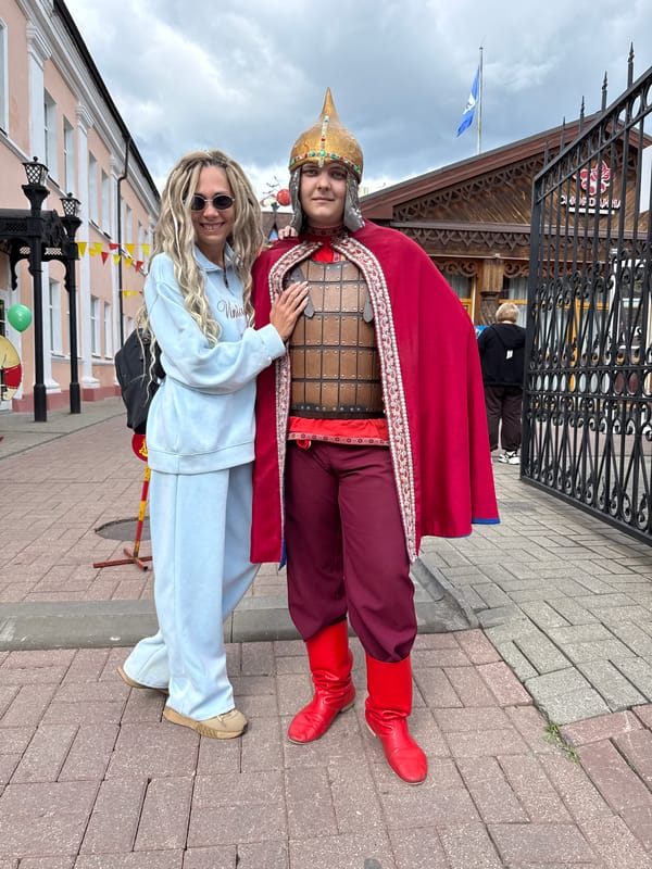 Visitors pose at Russian monument with historical costumes in Rusanovo