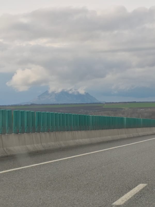 Highway scene documented in Konstantinovskaya with mountain backdrop
