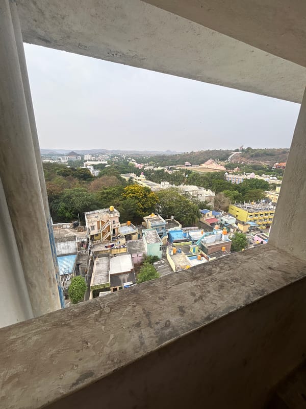 Puttaparthi townscape viewed through unfinished concrete window frame